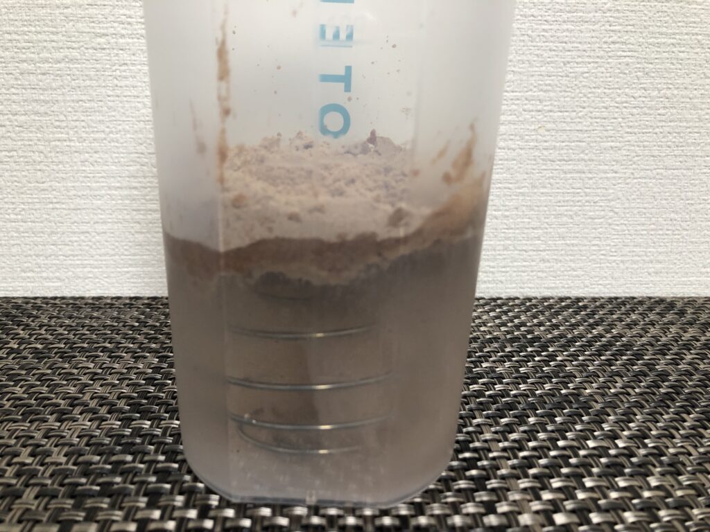 プロテインシェイカーに水とブレンダーボールを入れた後に、プロテインパウダーを入れた状態